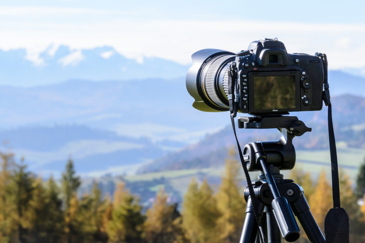 cta-02 DSLR camera on tripod capturing a stunning mountain view on a clear day.